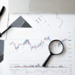 Magnifying glass on charts showing cloud cost optimisation data and trends