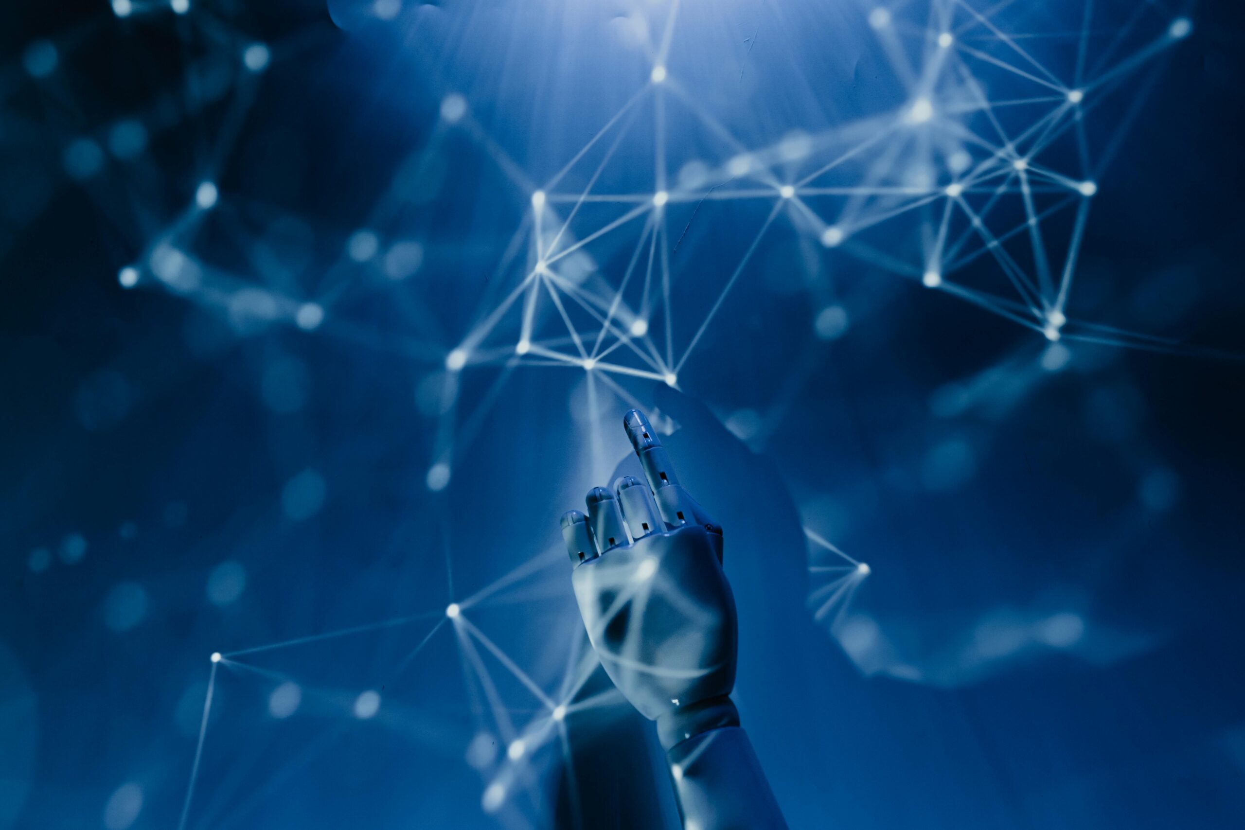 AI in the cloud: A robotic hand touches an abstract blue digital network, representing intelligent automation and optimised data operations.