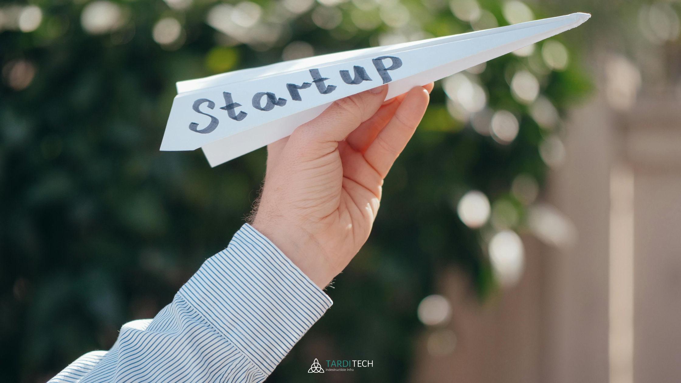 Person launching a paper airplane labeled ‘STARTUP,’ symbolizing scalable growth and the power of CloudOps in helping startups move fast and control cloud costs.