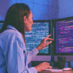 Engineer reviewing code across multiple screens, representing cloud infrastructure ownership, review responsibility, and operational visibility.